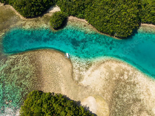 Flying above of natural transparent turquoise water in lagoon with coral reefs. Sohoton Cove. Seascape. Mindanao, Philippines.