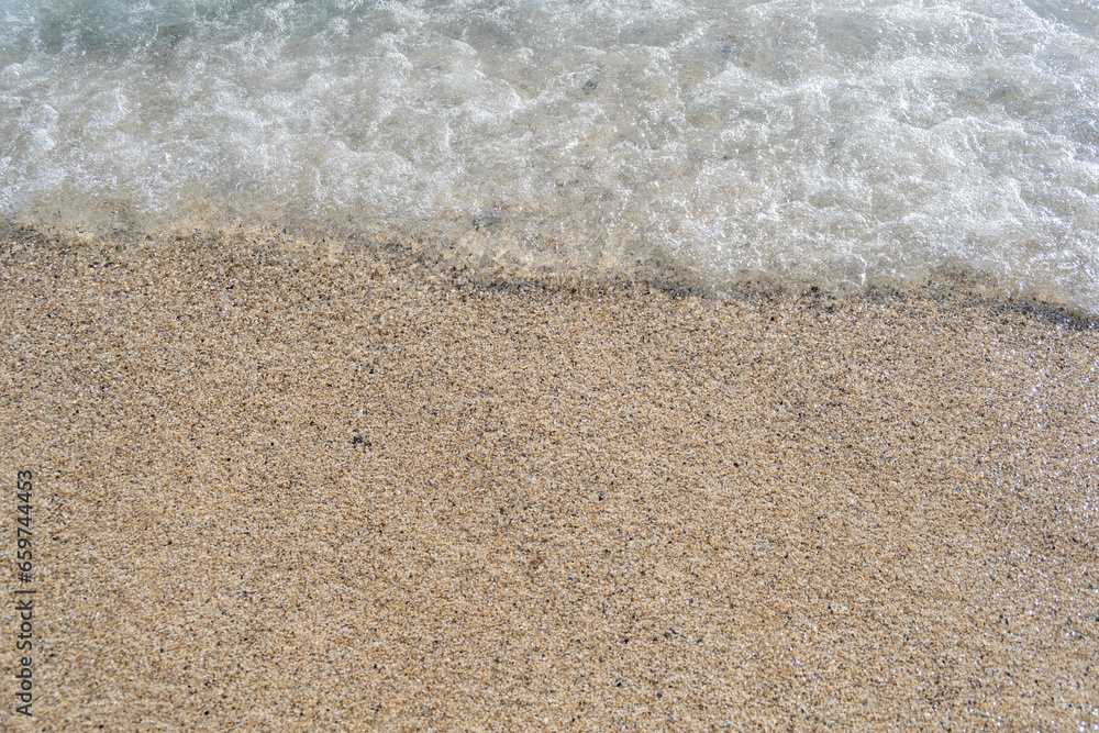 A soft wave runs on a sandy shore on a summer day. Empty space can be used as background for display or montage your top view products. A soft wave runs on a sandy shore on a summer day. Empty space can be used as background for display or montage your top view products.