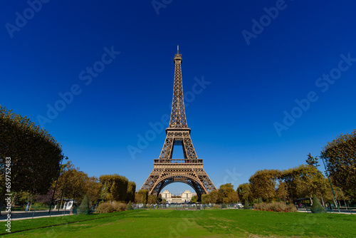 Eiffel Tower with Champs de Mars and sunny blue sky in Paris, France © momo11353