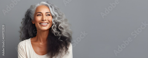 Black middle age woman portrait with healthy face skin. Open smiling beautiful aging mature woman with long hair. Beauty and cosmetics skincare advertising concept photo