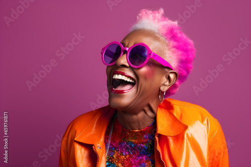 Happy senior black woman in colourful neon clothes on a pink background