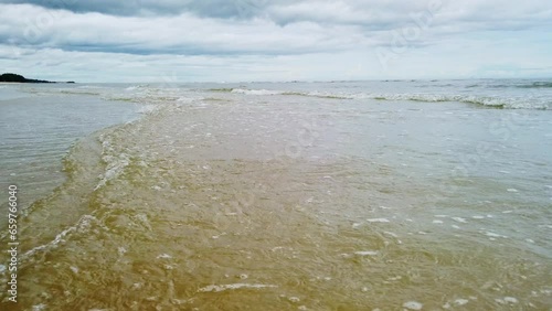 Beach ocean sea waves low angle,  Low angle of waves breaking the sand beach, breaking waves on the beach, Surf crashing on the beach.