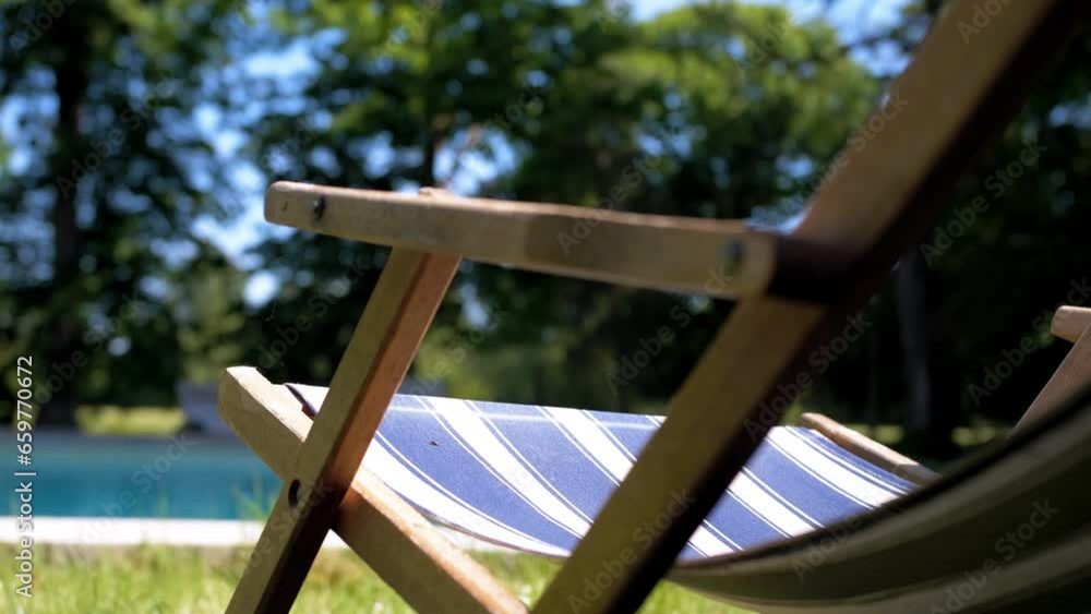 Relaxing arm chair with comfortable design outdoors near swimming pool Relaxing arm chair with comfortable design outdoors near swimming pool