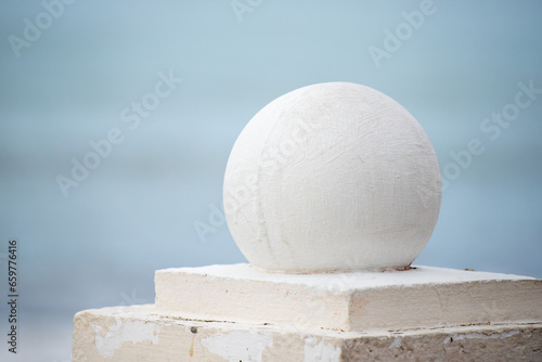 Round architectural ball in a park on the ground.