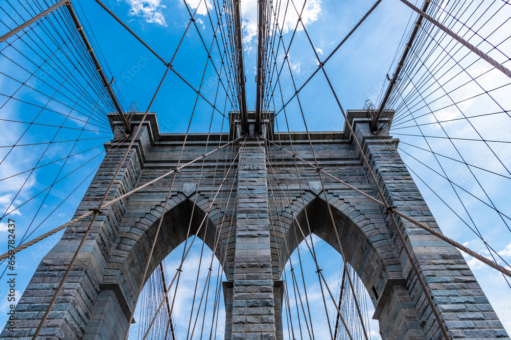 Fototapeta premium amazing scenery of brooklyn bridge in metropolis. architecture of historic bridge in brooklyn. american architecture landmark. way to manhattan. brooklyn bridge in new york. urban structure