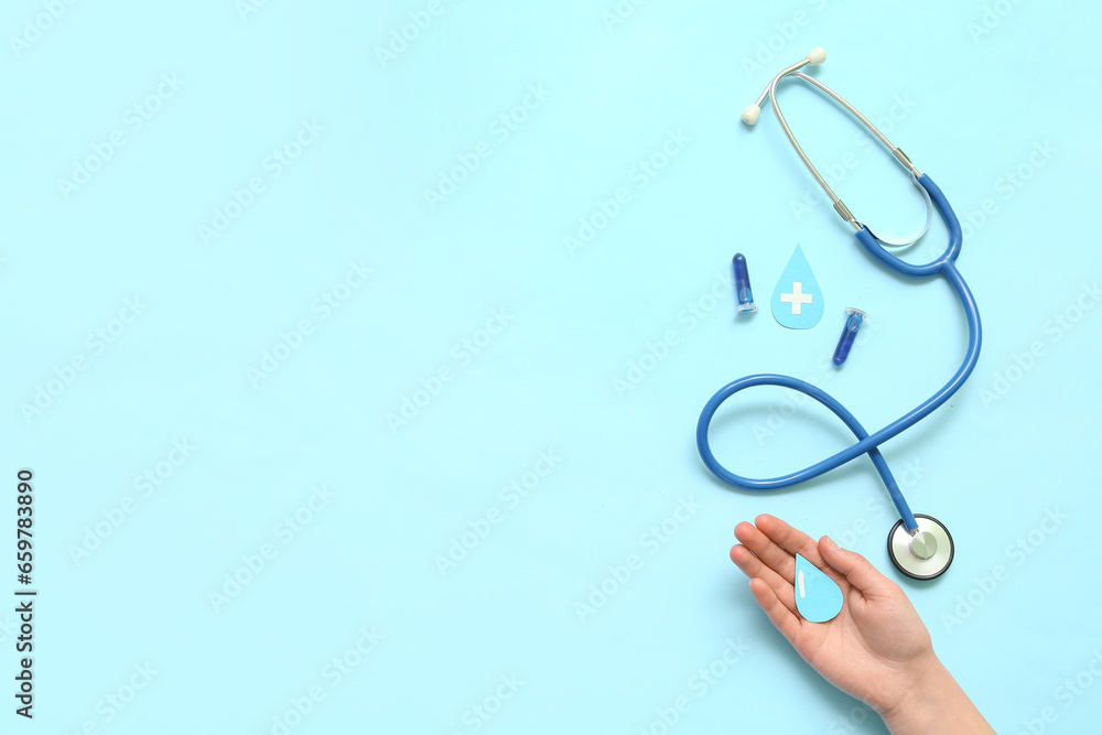 Woman with paper drops, test tubes and stethoscope on blue background. World Blood Donor Day Woman with paper drops, test tubes and stethoscope on blue background. World Blood Donor Day