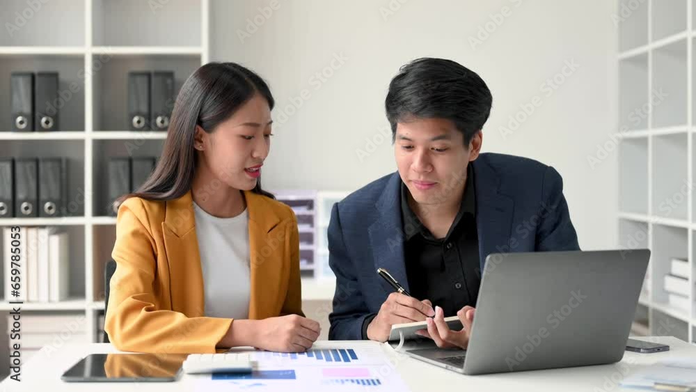 Asian business colleague business presents and explains and using laptop and tablet. Teamwork, financial marketing team, while sitting in modern office room.. Asian business colleague business presents and explains and using laptop and tablet. Teamwork, financial marketing team, while sitting in modern office room..
