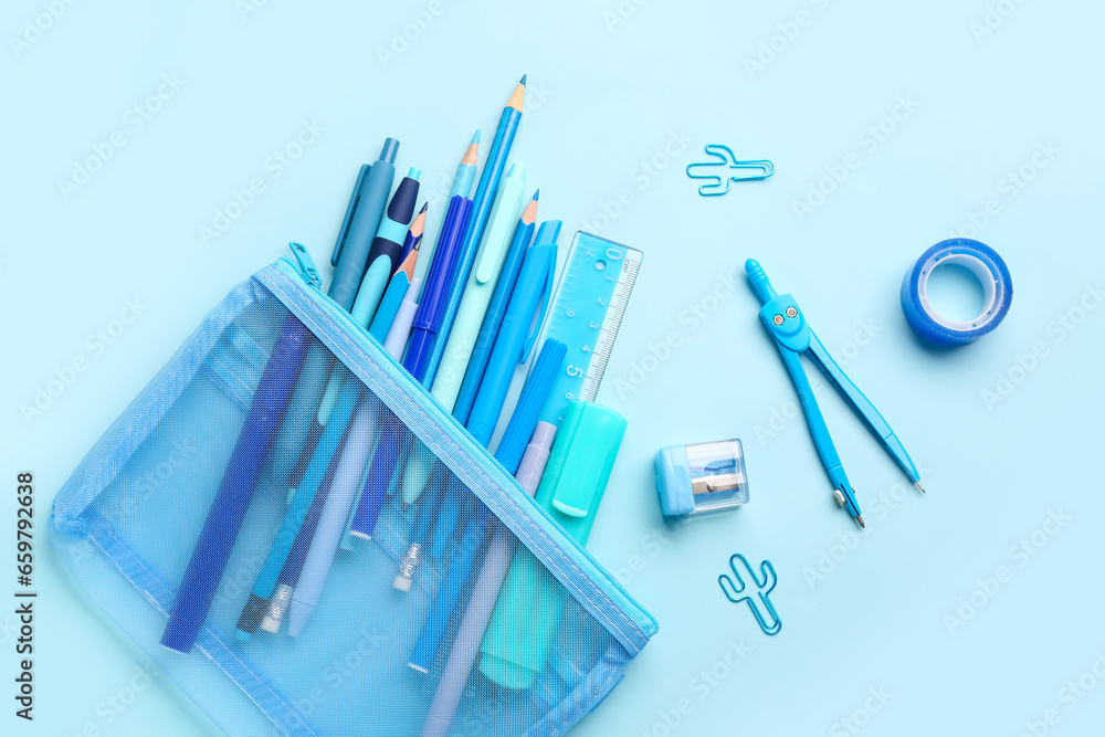 Stylish pencil case with different school stationery on blue background Stylish pencil case with different school stationery on blue background