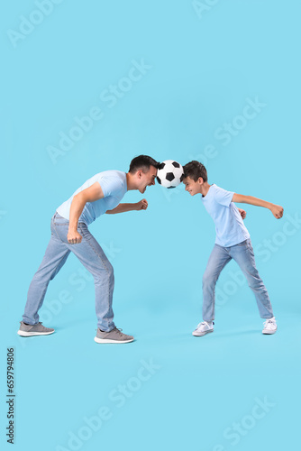 Little boy with his dad playing football on blue background
