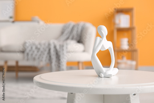 Small coffee table with decorative figurine in interior of living room  closeup