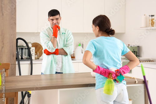 Happy young couple cleaning in kitchen