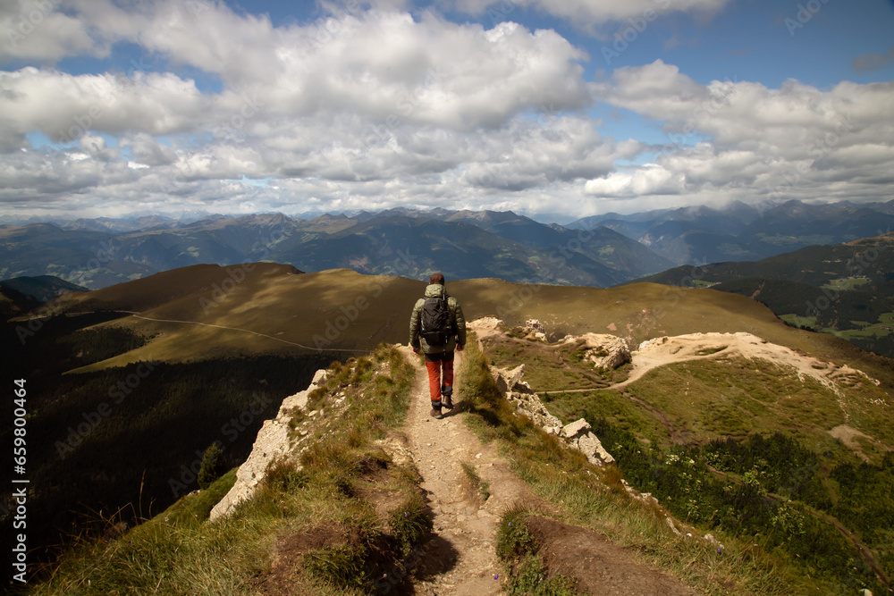 Man traveler traveling alone in breathtaking landscape of Dolomites Mounatains.
