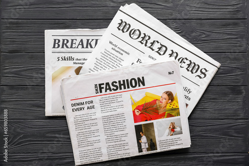 Morning newspapers on black wooden background photo