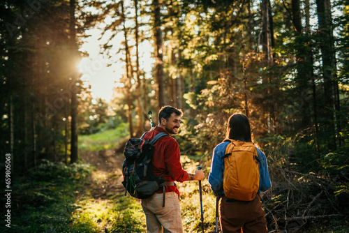Foto Two hikers, representing diversity, traverse a rugged terrain, their trusty back