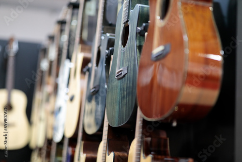 acoustic guitars hanging on a wall in music store