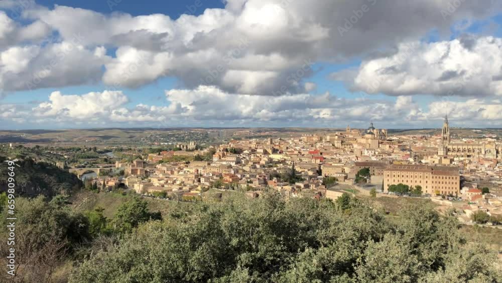 Panorama motion timelapse shot of rapid white cotton clouds passing over medieval buildings, castle, fortress, and tower in Toledo, Spain. Panorama motion timelapse shot of rapid white cotton clouds passing over medieval buildings, castle, fortress, and tower in Toledo, Spain.