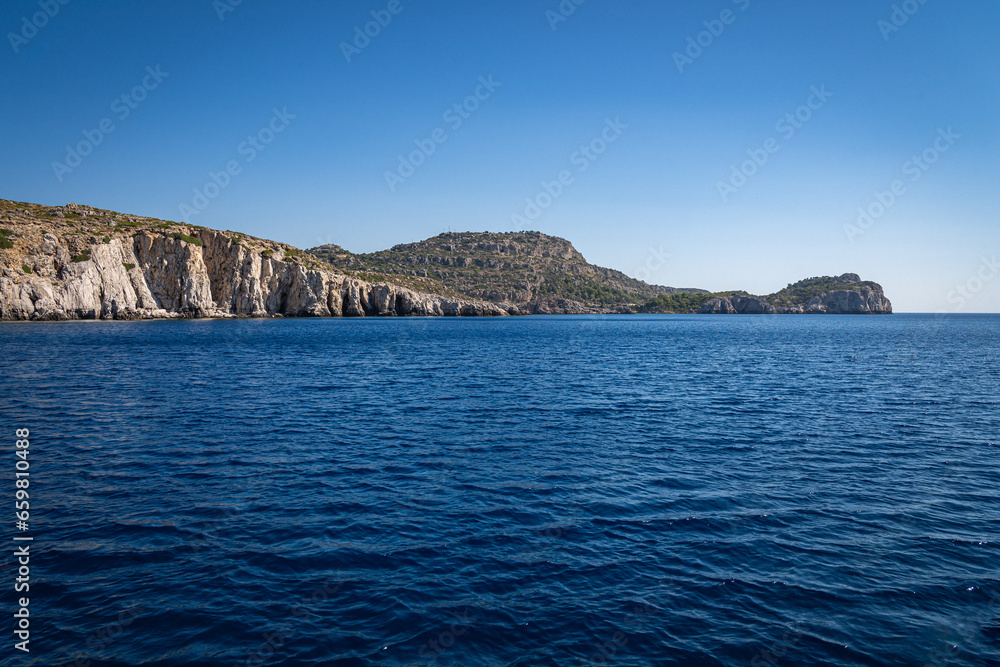 Majestic Rock Formations of Rhodes: A sea-level view of the stunning cliffs and geological wonders along the island's coastline, where the Mediterranean's blue embraces Grecian landscapes.