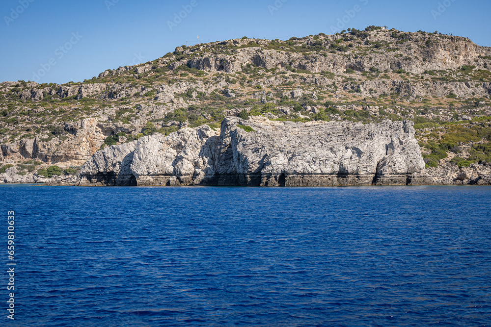 Majestic Rock Formations of Rhodes: A sea-level view of the stunning cliffs and geological wonders along the island's coastline, where the Mediterranean's blue embraces Grecian landscapes.