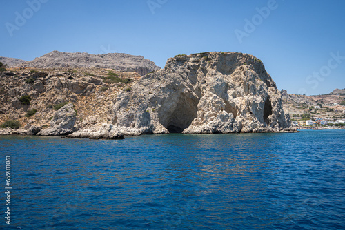 Majestic Rock Formations of Rhodes  A sea-level view of the stunning cliffs and geological wonders along the island s coastline  where the Mediterranean s blue embraces Grecian landscapes.