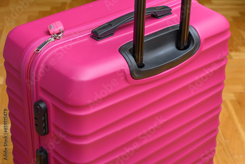 Zbliżenie na różową walizkę na kółkach spakowaną na podróż 
