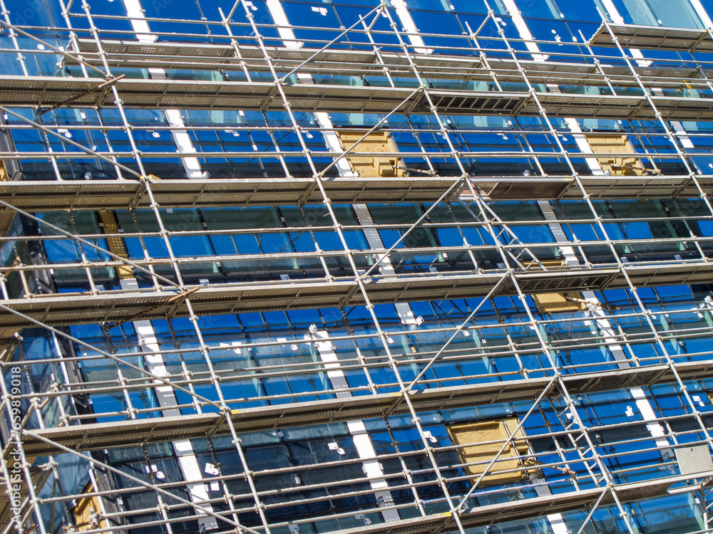 building under construction with scaffolding in place - blue sky
