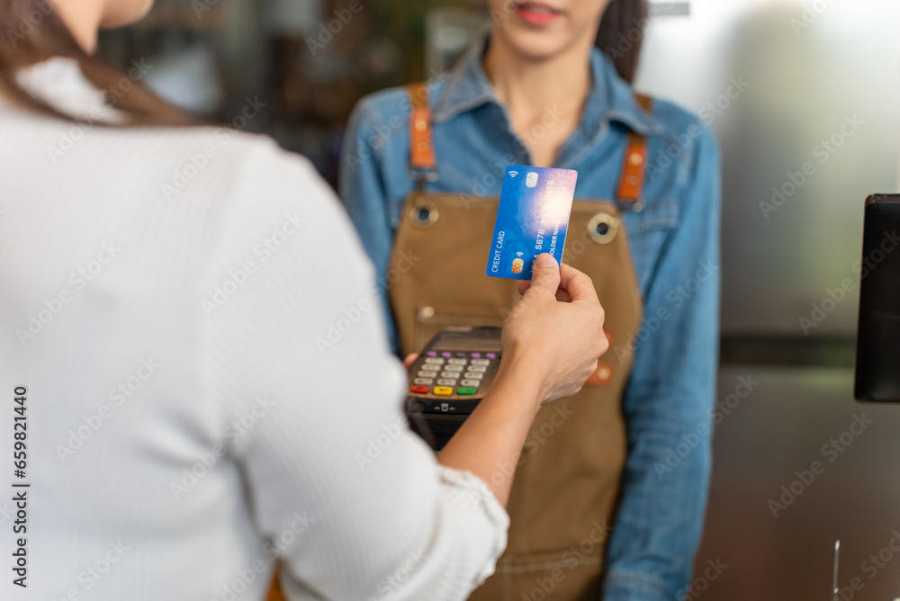 Contactless payment, Unrecognizable woman pay for coffee by credit card at coffee shop. Small business, Business owner. Contactless payment, Unrecognizable woman pay for coffee by credit card at coffee shop. Small business, Business owner.