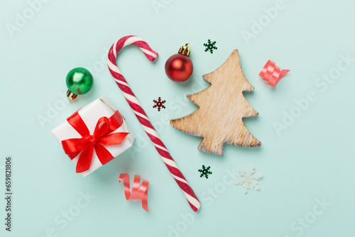 Miniature christmas tree with gift box and decor on color background