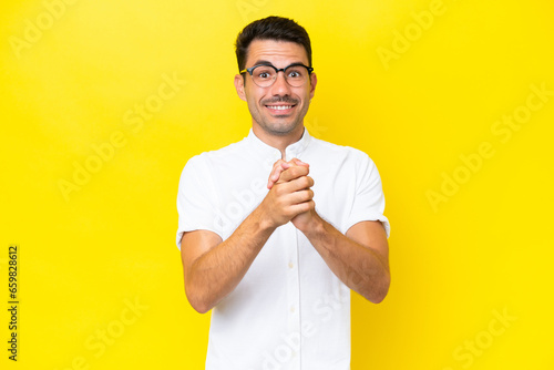 Young handsome man over isolated yellow background laughing
