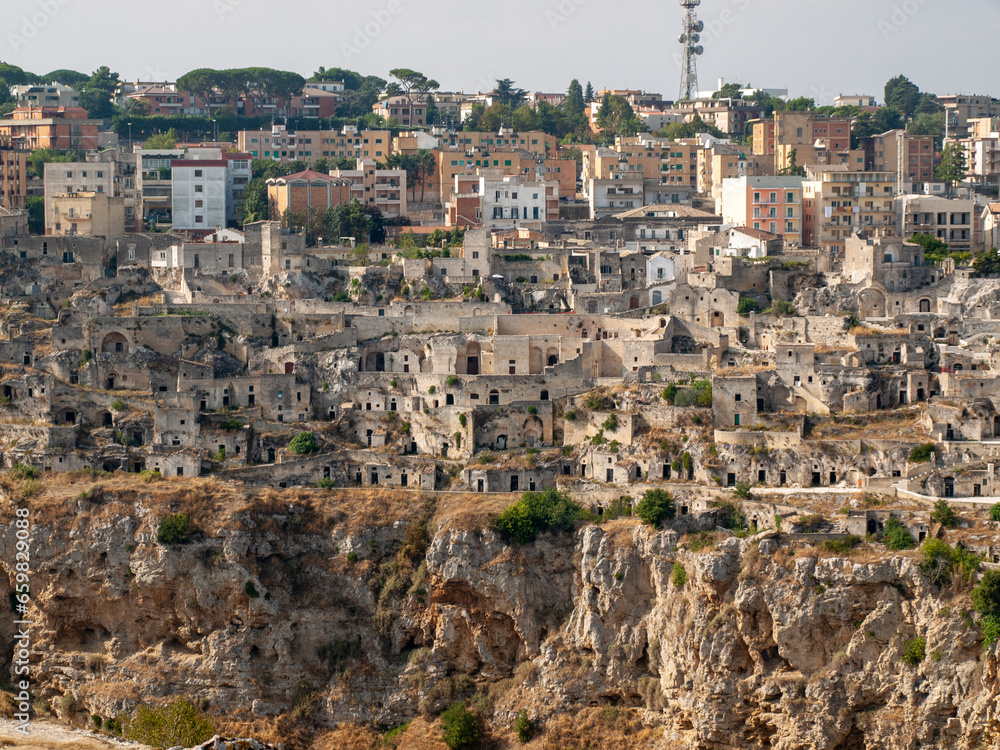 Obraz premium Panoramic view of Sassi di Matera a historic district in the city of Matera, well-known for their ancient cave dwellings from the Belvedere di Murgia Timone, Basilicata, Italy