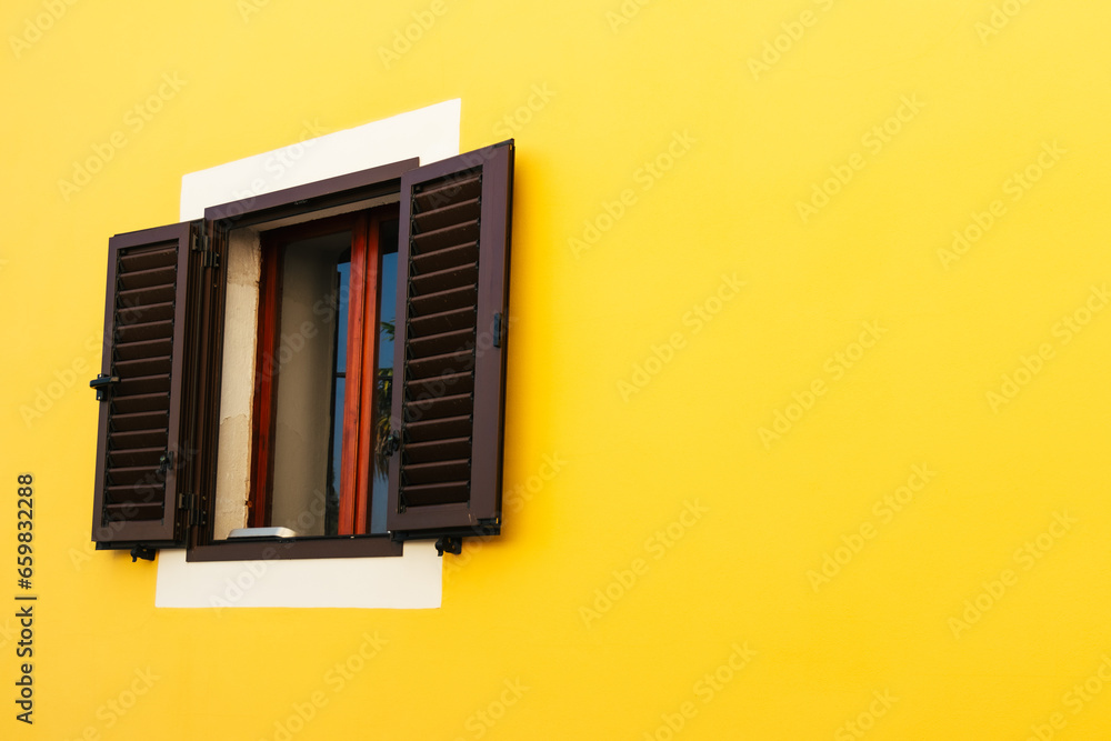 Sunlit Elegance: Yellow Wall with Brown Shutters in Croatia