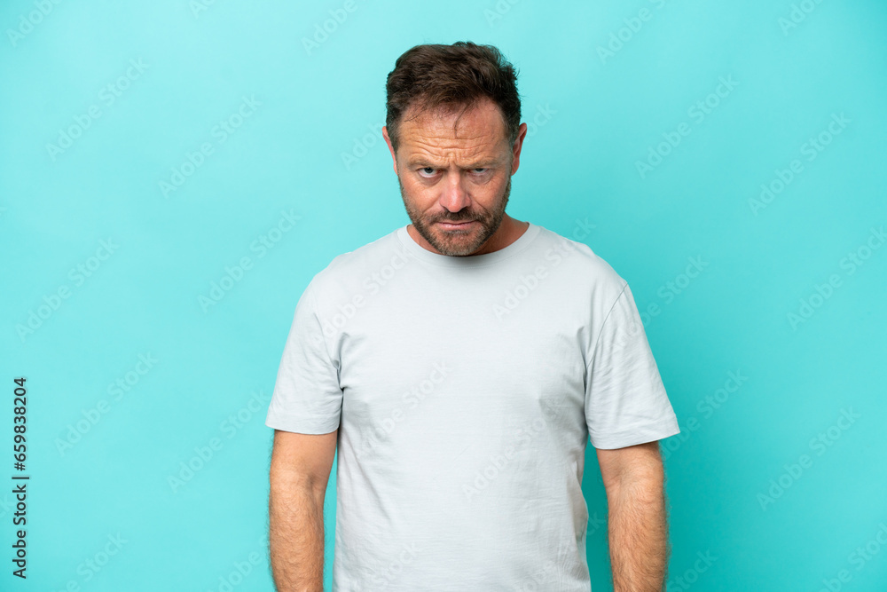 Middle age caucasian man isolated on blue background with sad expression Middle age caucasian man isolated on blue background with sad expression