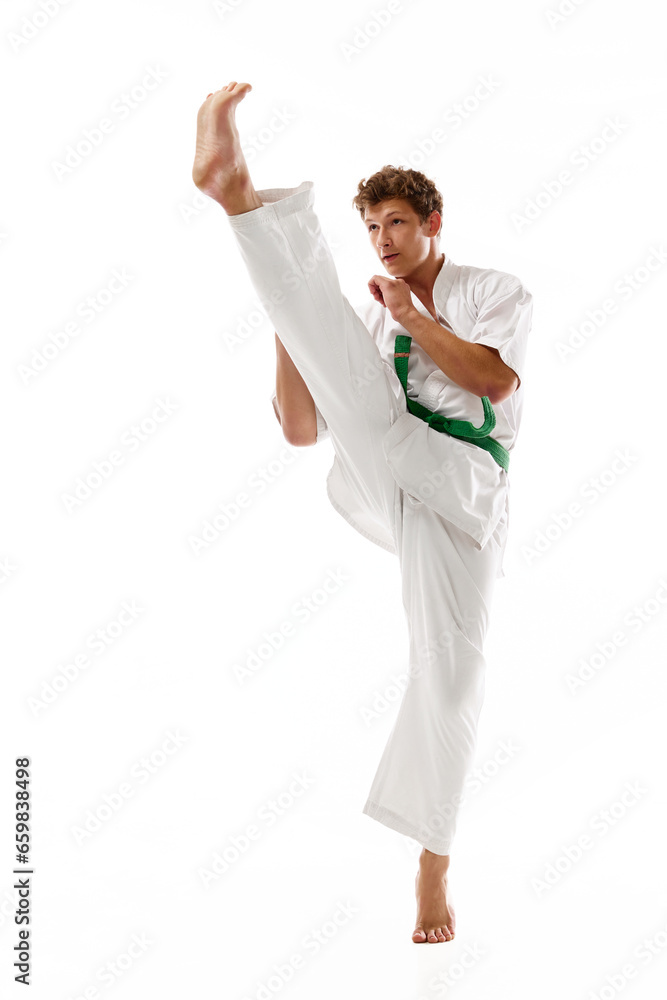 Dynamic image of young man in white kimono training isolated on white studio background. Karate, taekwondo, judo athlete. Concept of martial arts, combat sport, energy, strength, health. Ad Dynamic image of young man in white kimono training isolated on white studio background. Karate, taekwondo, judo athlete. Concept of martial arts, combat sport, energy, strength, health. Ad