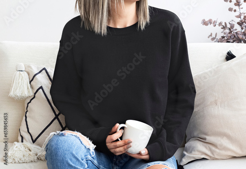 Girl in template blank black sweatshirt home,  coffee design. Black hoodie 18000 model mock up blank, empty, copy space

