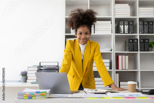 African American businesswoman working with laptop Financial charts and graphs check data in paper documents at table in office