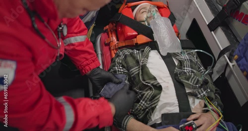 Patient, paramedic and blood pressure with oxygen mask in ambulance for emergency, injury or healthcare with neck brace. First responder, person and anesthesia for medical health, support or victim photo