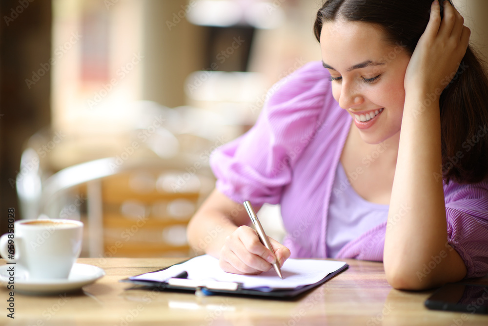Happy woman filling survey in a coffee shop Happy woman filling survey in a coffee shop