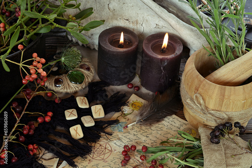 Runes, black candles and old manuscript on altar table. Occult, esoteric and divination still life. Mystic Halloween background with vintage objects for magic ritual