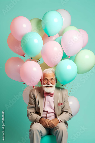Happy old man posing on his birthday with balloons