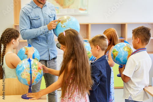 Students learning through globes in class