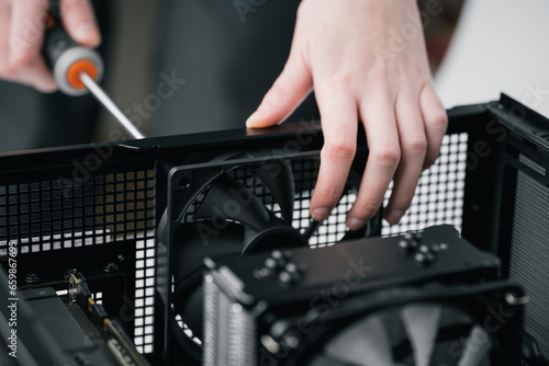 Computer technician installs cooling system of computer. Assembling PC
