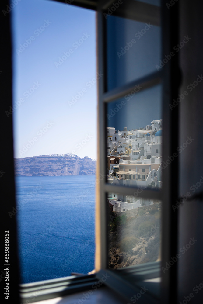 Townscape touristic village reflected on a window glass with a beautiful scenic of Santorini, Greek Islands