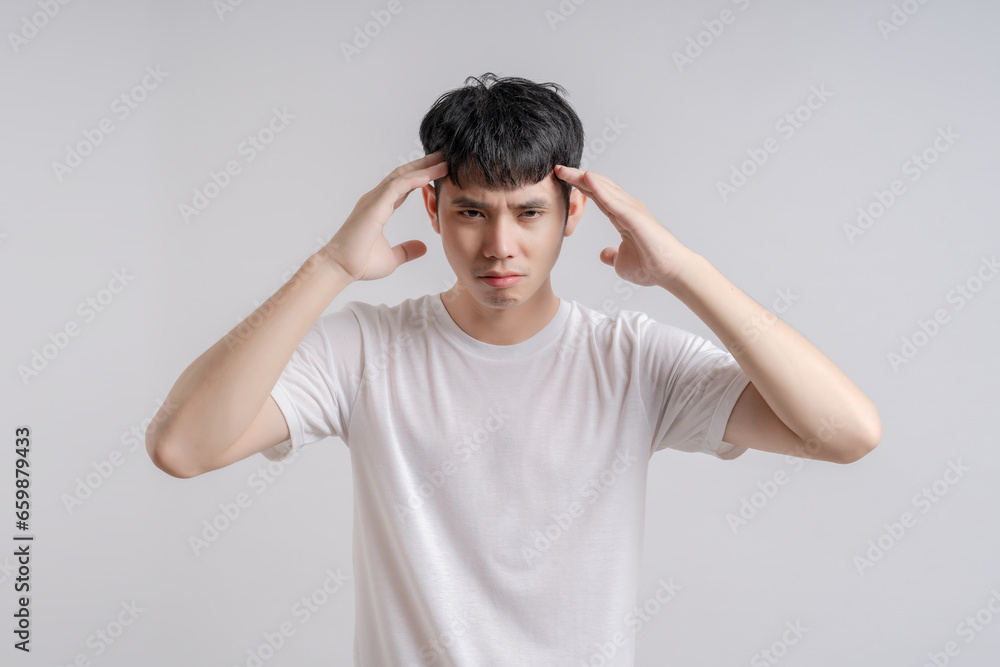 Handsome young man touched his head because he had headache and was angry. Handsome young man touched his head because he had headache and was angry.