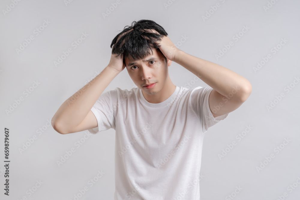 Handsome young man touched his head because he had headache and was angry. Handsome young man touched his head because he had headache and was angry.