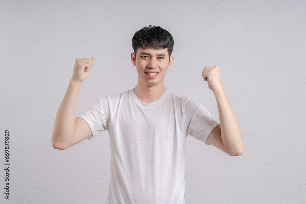 Handsome young man raised his fist and showed happy expression of excitement and joy on his face. Handsome young man raised his fist and showed happy expression of excitement and joy on his face.