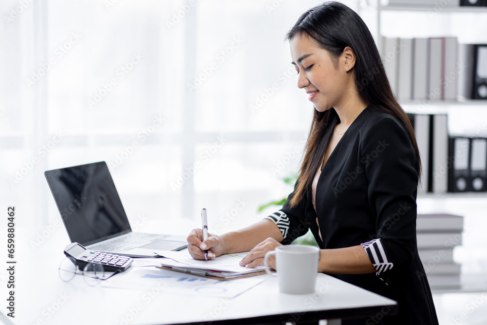 Asian Businesswoman Using laptop computer and working at office with calculator document on desk, doing planning analyzing the financial report, business plan investment, finance analysis concept.
Asian Businesswoman Using laptop computer and working at office with calculator document on desk, doing planning analyzing the financial report, business plan investment, finance analysis concept.