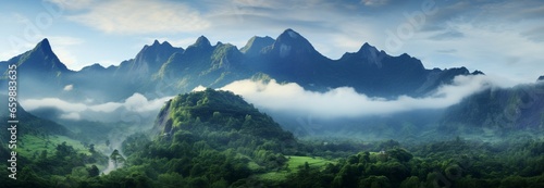 A misty mountain panorama: lush green slopes, peaks shrouded in ethereal fog © Muhammad Shoaib