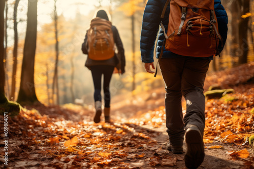 Group of tourists walks along the path of the autumn forest. Feet close-up. Traveling in a small group.