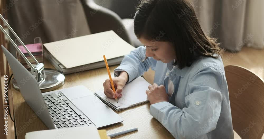 Schoolboy, seated at desk, diligently writes in notebook. With a concentrated expression, he meticulously records thoughts and notes, exemplifying the essence of dedicated study. Schoolboy, seated at desk, diligently writes in notebook. With a concentrated expression, he meticulously records thoughts and notes, exemplifying the essence of dedicated study.
