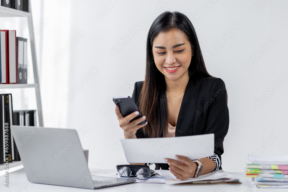Portrait of young asian woman company worker in documents during using smartphone and working on Laptop, Portrait of young asian woman company worker in documents during using smartphone and working on Laptop,