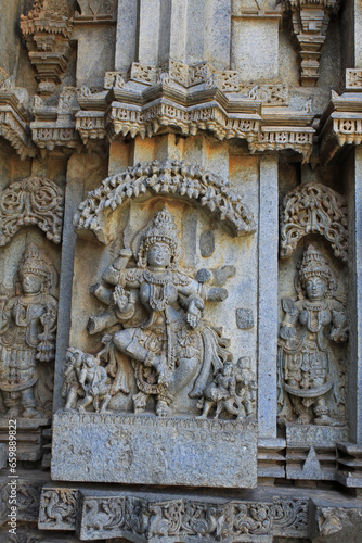 Close up of goddess Nritya Lakshmi sculpture under eves on shrine outer wall in the Chennakesava Temple, Hoysala Architecture, Somanathpur, Karnataka, India photo